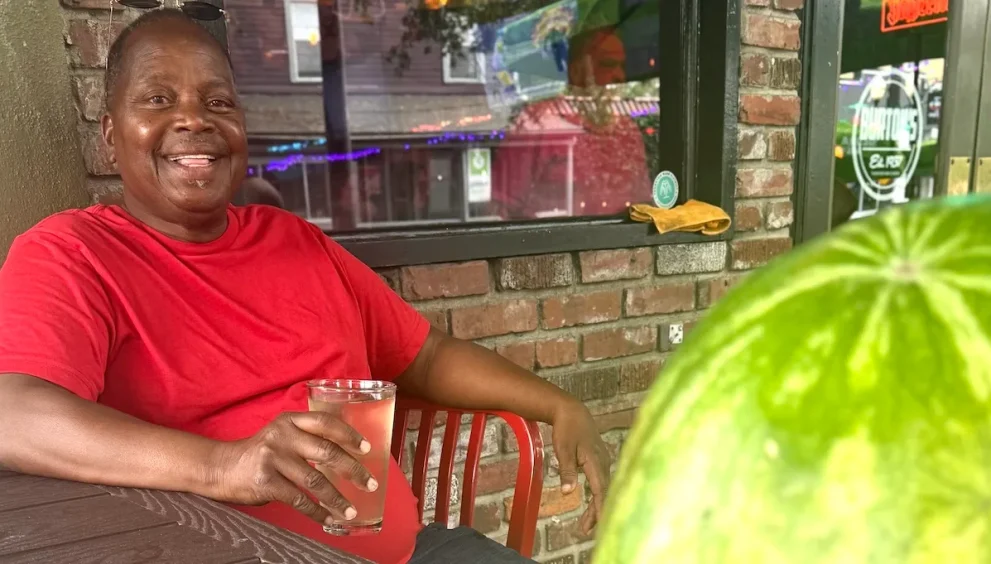 Michael Sears, a Gifford artist and Highwaymen tradition painter, photographed at Burton’s in Orlando with a watermelon and a poster for his documentary La Dolce Prospettiva.