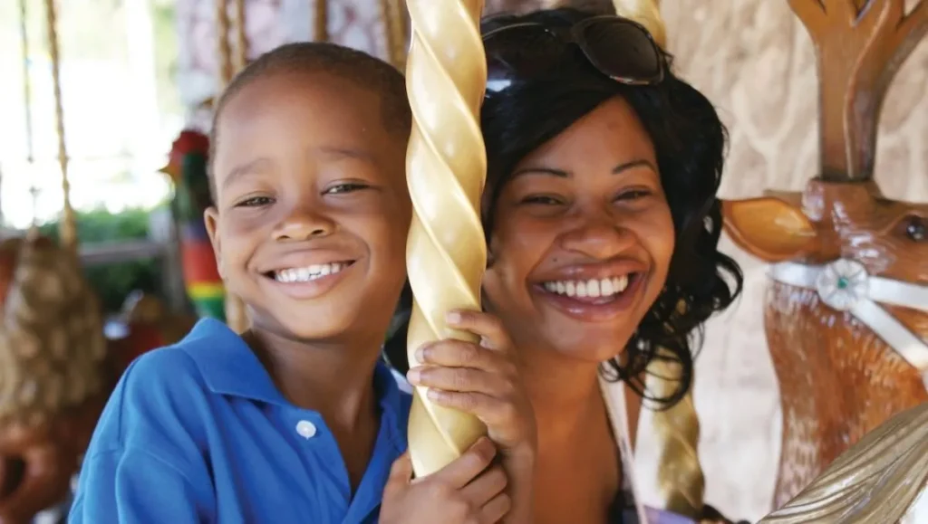 Mother and son riding the Wish Carousel at Give Kids The World Village in Kissimmee