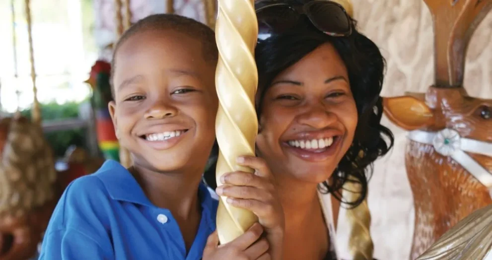 Mother and son riding the Wish Carousel at Give Kids The World Village in Kissimmee