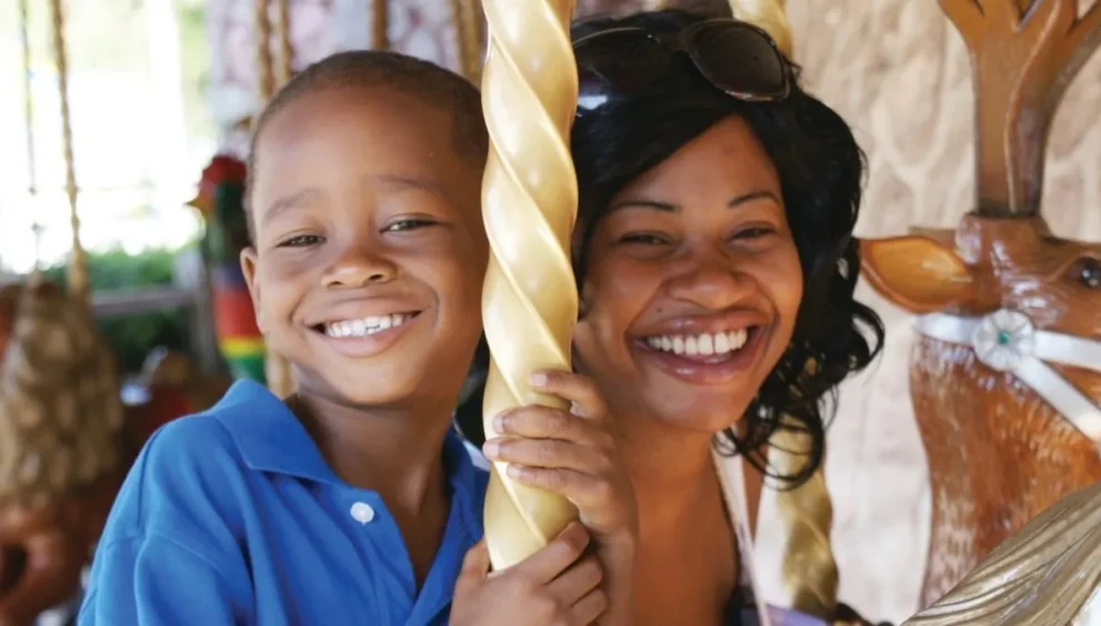 Mother and son riding the Wish Carousel at Give Kids The World Village in Kissimmee