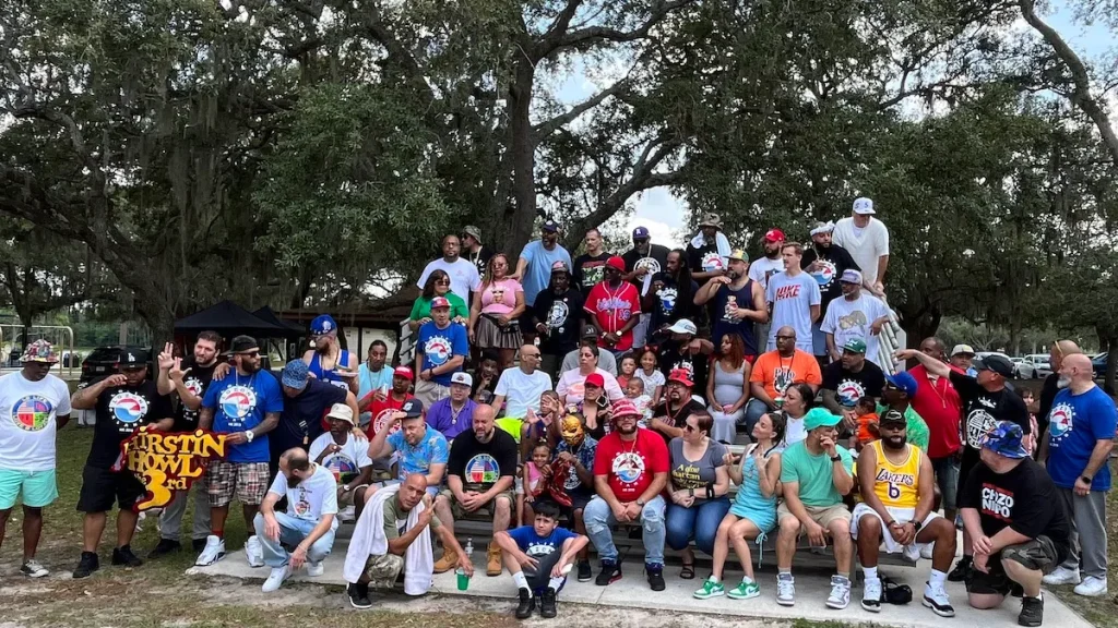 Multicultural crowd at Love & Loyalty Weekend BBQ event in Orlando park setting