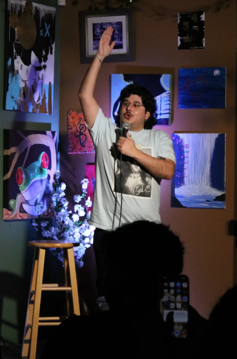 Comedian with arm raised as he tells a joke