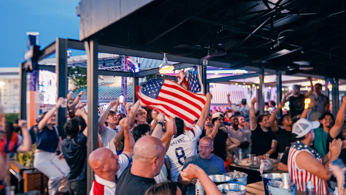 American flag waves above fans during Orlando's World Cup celebration.